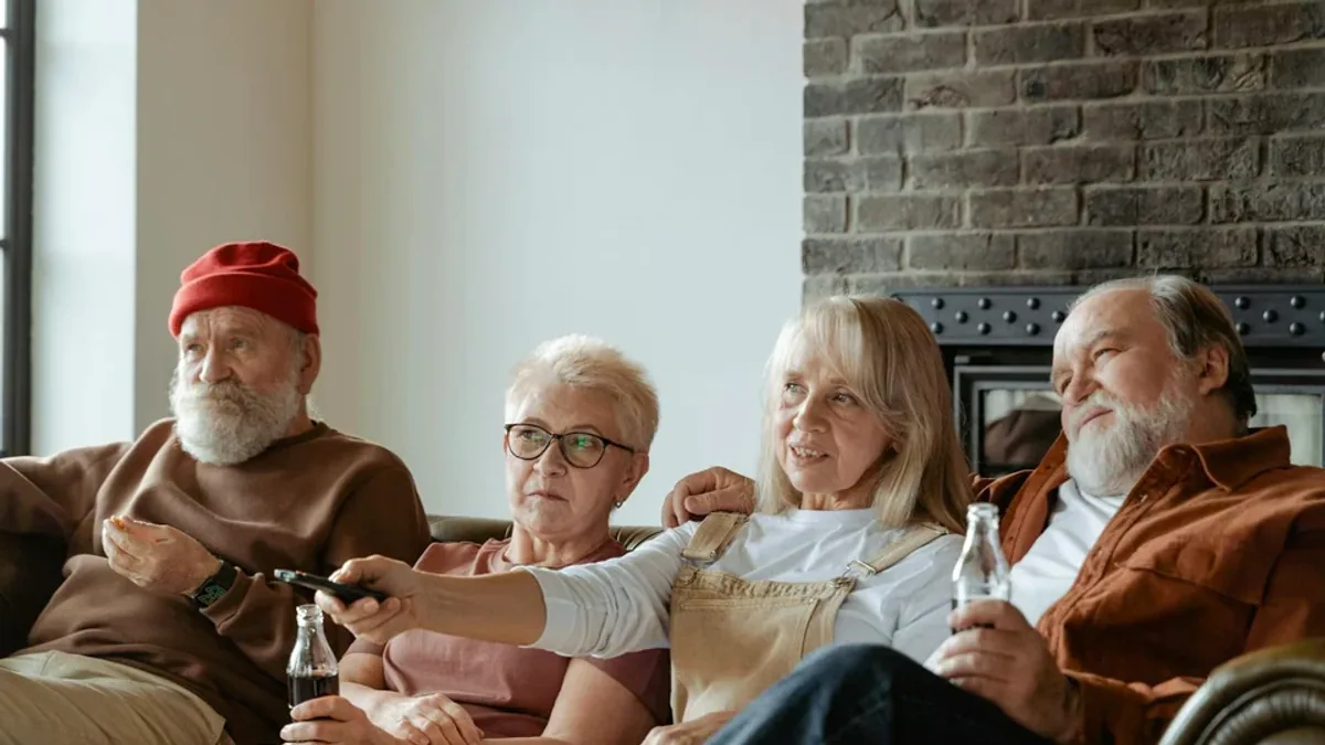 An older couple watching telly in their sitting room